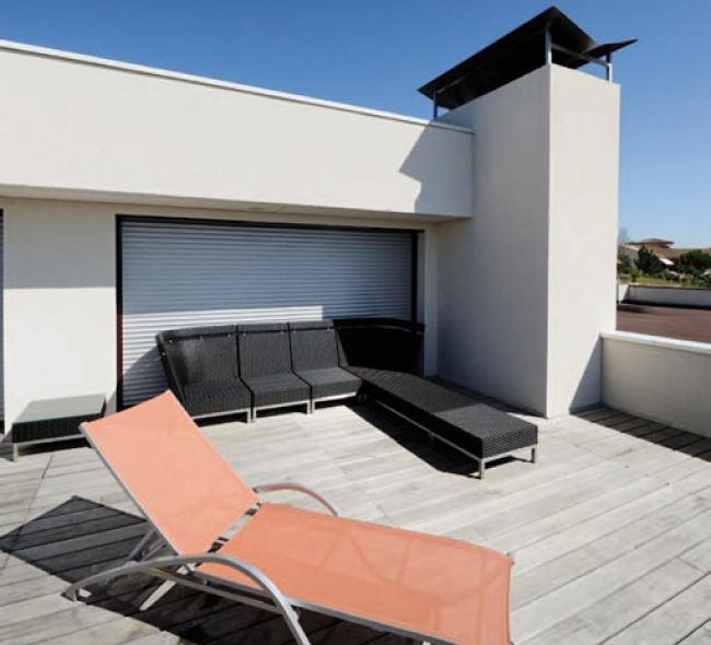 Photo d'un grand volet blanc sur une grande fenêtre de terrasse